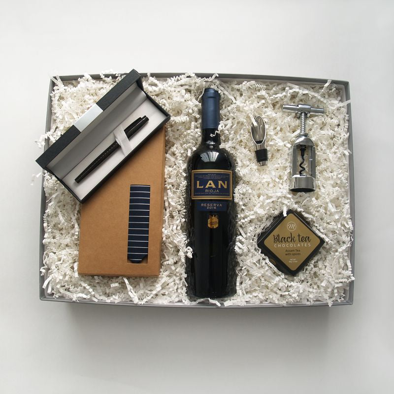 Caja regalo original para el día del padre. Un regalo elegante que incluye un vino Rioja, una corbata, un sacacorchos, chocolate y un moderno bolígrafo. 