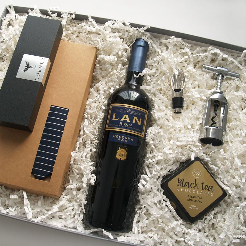 Caja regalo original para el día del padre. Un regalo elegante que incluye un vino Rioja, una corbata, un sacacorchos, chocolate y un moderno bolígrafo.